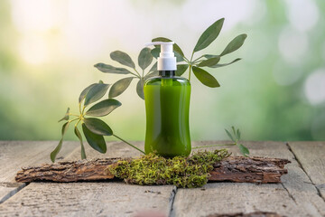 A bottle dispenser for skin care products on a wooden background surrounded by tree bark, moss and green leaves