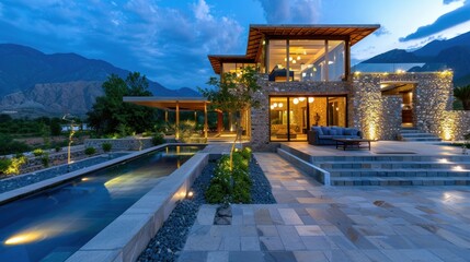Modern architectural design of luxury villa with pool and mountain view during twilight, showcasing outdoor living space, and landscape lighting