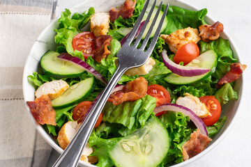 salad top with chopped bacon and hicken