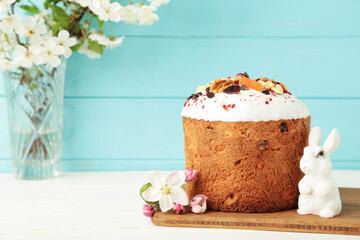 Traditional easter cakes with colorful sprinkles, with eggs, a bunny figurine, and spring flowers, creating a festive holiday scene