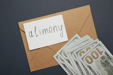 Envelope with word Alimony and money on dark blue background
