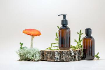 containers for skin care products on a wooden podium and fly agaric surrounded by moss and green leaves