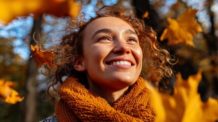 Woman smiling amidst autumn leaves.