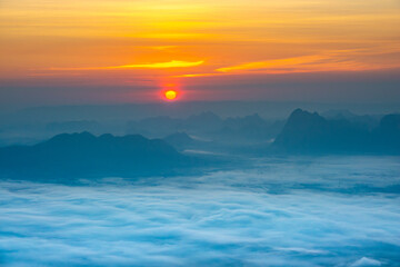 Obraz premium Scenic sunrise above mountain layers and morning fog under a vibrant sky.