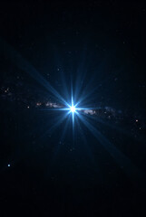 Bright blue star with strong light rays in deep space galaxy