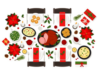Top-down view of a festive Christmas dinner table setting with a roasted ham, side dishes, poinsettias, gifts, and candles arranged on a white tablecloth.