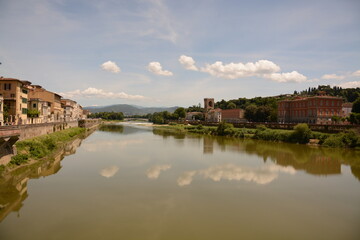 Fototapeta premium Reflejos de la Toscana: Serenidad Fluvial en una Ciudad de Ensueño