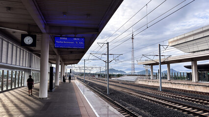 Empty high-speed train station under cloudy sky
