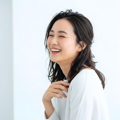 Young asian woman laughing joyfully with eyes closed