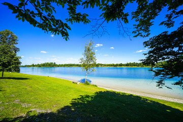 View of Lake Karsfeld and the surrounding landscape. Nature by the lake near Karsfeld in Upper Bavaria.
