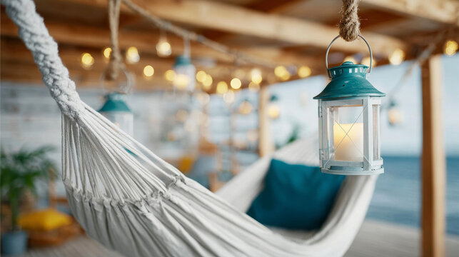 White rope hammock swinging gently outdoors creating a relaxing coastal atmosphere by the ocean, cozy ambiance with lanterns and string lights