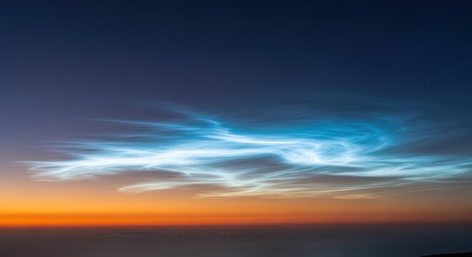 Noctilucent clouds in the night sky over horizon at dusk