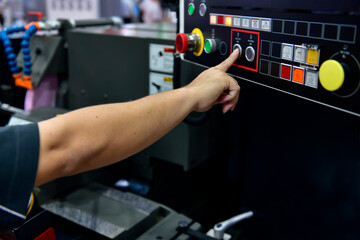 Machine operator hand turns on control panel of industrial machine. technician push button on control panel	