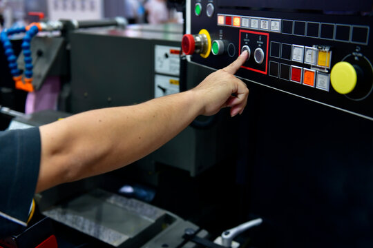 Machine operator hand turns on control panel of industrial machine. technician push button on control panel	