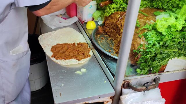 Authentic Istanbul Street Food: Master Serving Cig Kofte Durum with Lavash Bread