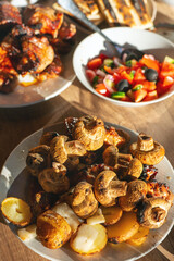 Pork shashlik, champignons, potatoes with lard fried on the grill in a plate on the table