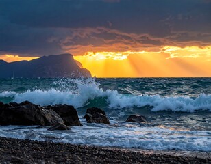 Waves crash on a rocky beach at sunset, with mountains in the distance under a dramatic, cloud-filled sky