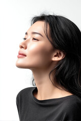 Side view of beautiful happy Asian woman with smooth skin, black hair, natural makeup, and soft smile on white background