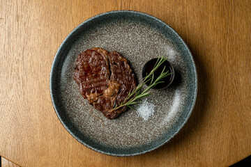 A perfectly grilled steak rests on a textured plate, showcasing its sear marks