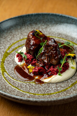 Tender beef pieces are beautifully arranged on a plate, drizzled with glossy sauce. Colorful garnishes add freshness, making the dish visually stunning. Perfect for food lovers