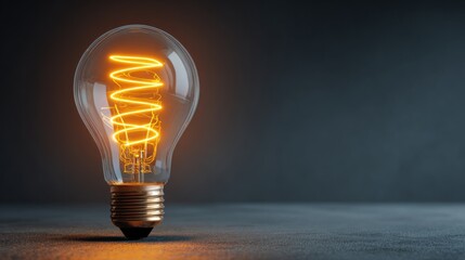 Glowing incandescent light bulb on dark background
