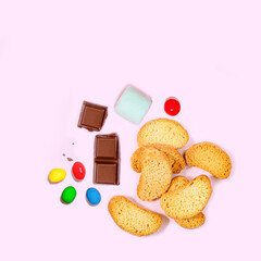 Assorted Sweet Treats: Chocolate, Marshmallows, Candies, and Biscuits on Pink