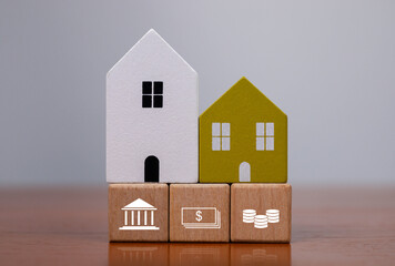 A concept image of wooden houses with banking, cash and coin icons, representing real estate finance, mortgage planning, investment strategy and financial stability for long-term economic security.