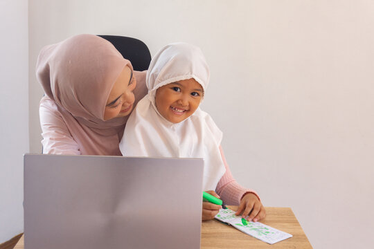 Happy mom working remotely and daughter drawing. Modern family life - Powered by Adobe