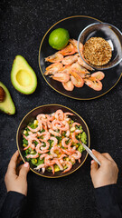 Woman's Hands Mixing Healthy Shrimp, Avocado and Mango Salad Bowl
