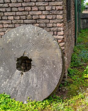 old millstone on a brick wall