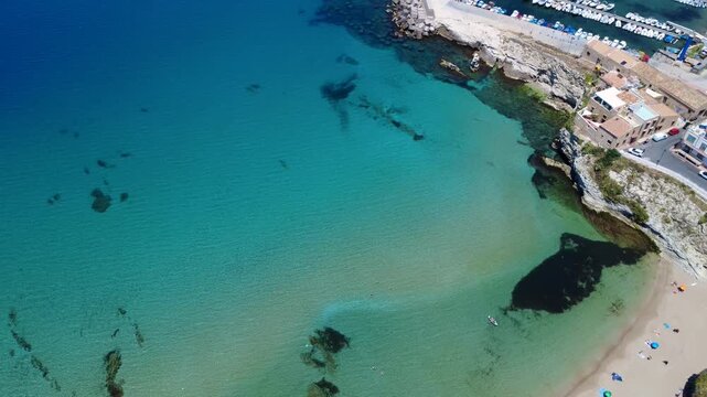 Crystal Clear Water and Sandy Beach at a Coastal Harbor During a Sunny Day. Terrasini, Sicily, Italy