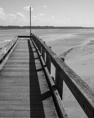 Fototapeta premium wooden jetty on the north sea coast, greyscale shot