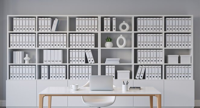 Organized office interior with a wall of white binders on shelves. Modern minimalist workspace with a desk and laptop for data management