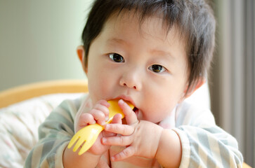 フォークを口に入れる赤ちゃん