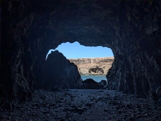 View of ocean waves and rugged coastline cliffs from inside dark cave in Ajuy, Fuerteventura, Spain