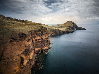 Dramatic volcanic cliffs and serene ocean view at Ponta de S&atilde;o Louren&ccedil;o, Madeira Island, Portugal &ndash; panoramic coastal landscape with sailboats, hiking trails, and wild natural beauty.