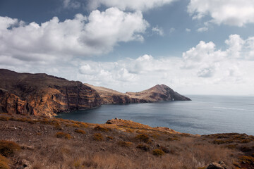 Dramatic volcanic cliffs and serene ocean view at Ponta de S&atilde;o Louren&ccedil;o, Madeira Island, Portugal &ndash; panoramic coastal landscape with sailboats, hiking trails, and wild natural beauty.