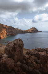 Dramatic volcanic cliffs and serene ocean view at Ponta de S&atilde;o Louren&ccedil;o, Madeira Island, Portugal &ndash; panoramic coastal landscape with sailboats, hiking trails, and wild natural beauty.