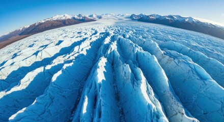 Glacial ice field aerial view with mountain range horizon under clear sky