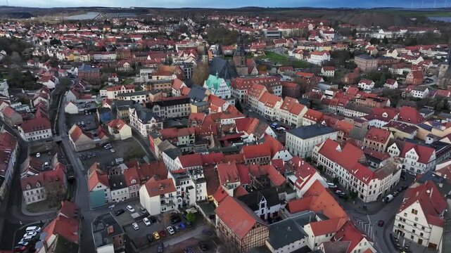 Drone flying toward Luther City Eisleben&rsquo;s market square after sunset, cool pre-Christmas atmosphere, historic town hall and church in Saxony-Anhalt.