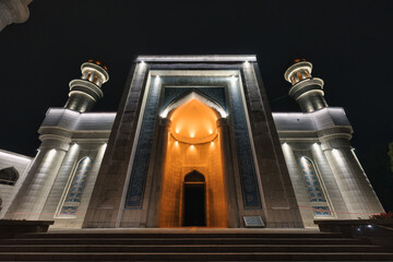 Fototapeta premium Illuminated facade of Central Mosque with entrance lighting in the night at Almaty, Kazakhstan