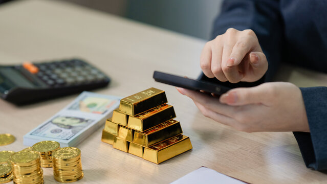 businesswoman investing in gold with digital device