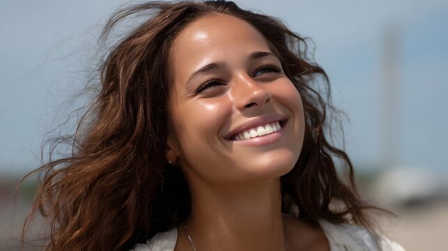A young woman beams with a radiant smile looking up towards the sun on a breezy day - Powered by Adobe