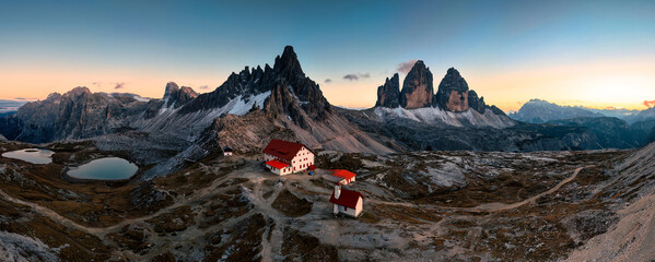 Scenic view of Tre Cime di Lavaredo peaks with Laghi dei Piani and Rifugio locatelli mountain hut in the sunset at Dolomites, italy © Mumemories