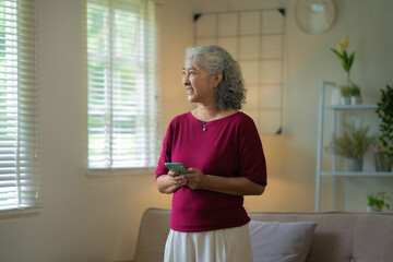 relaxed senior woman stays connected with social media on her smartphone at home