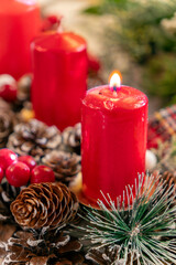 Candles illuminate festive table setting with pinecones and holiday decor during Christmas season