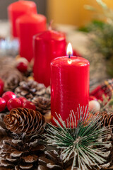 Red candles surrounded by pine cones and holiday decorations create a warm atmosphere during the festive season