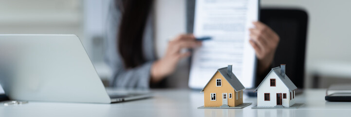 professional evaluates home loan and house contract and valuation at office desk