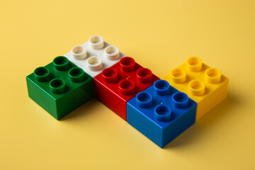 Colorful toy blocks building creativity on yellow background