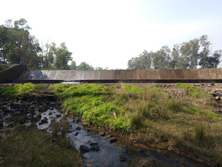 Water flowing over a small dam in a natural landscape